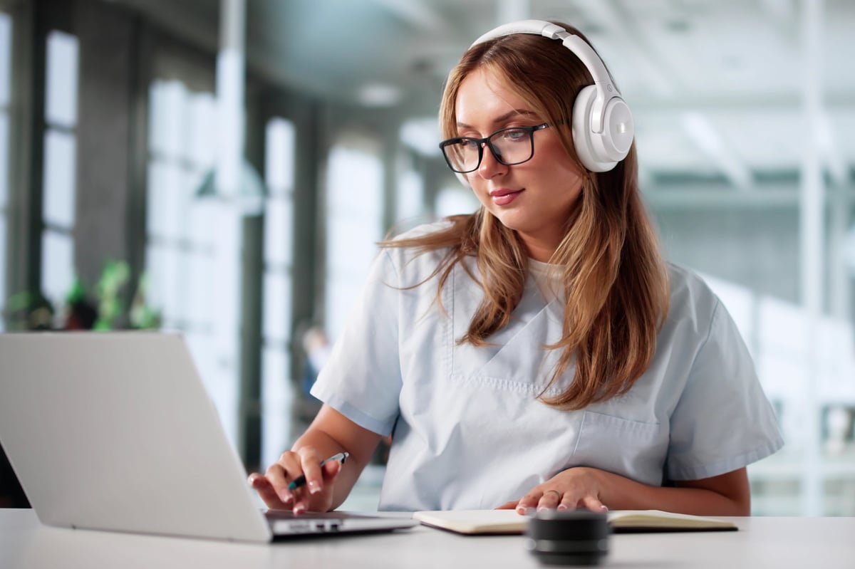Student learning on laptop with headphones