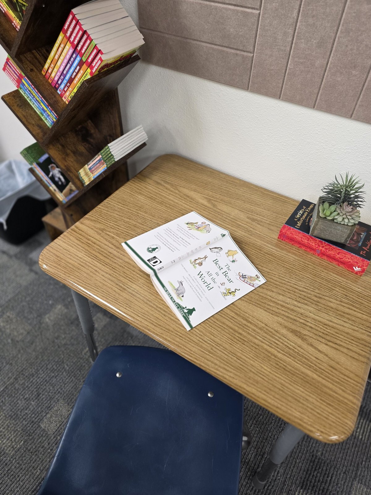 Student desk with books beside the reading bookshelf
