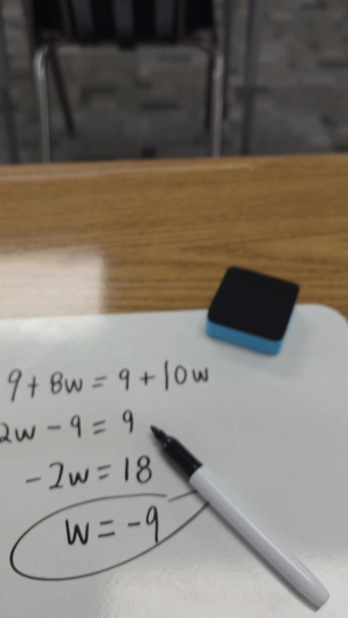 Algebra problem solved step by step on a mini whiteboard